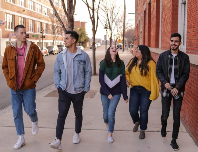 three men and laughing two women walking side by side