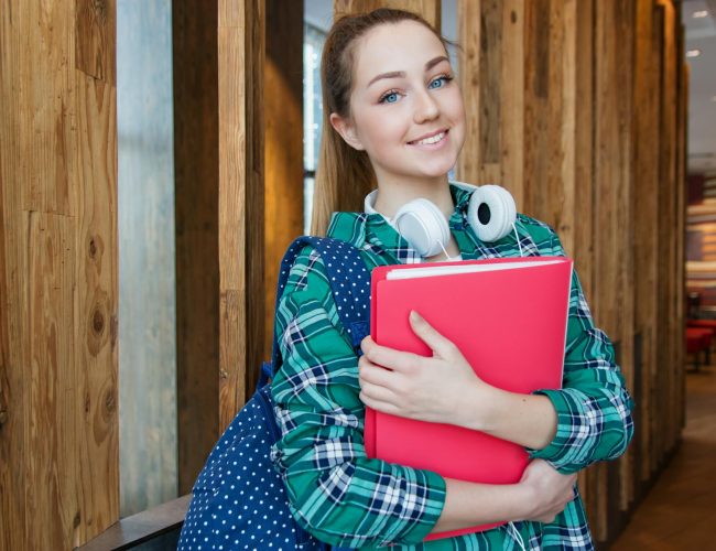 woman standing in hallway while holding book