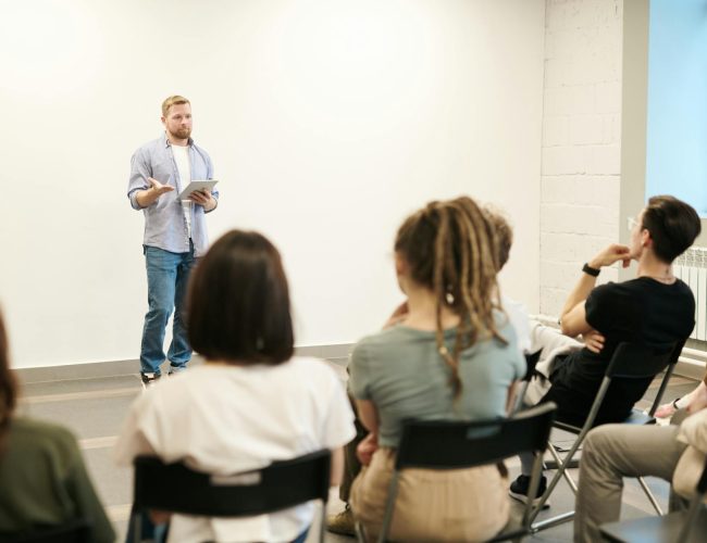 man wearing gray dress shirt and blue jeans