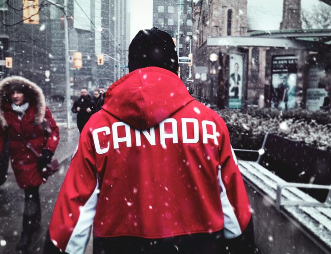 man in red hoodie walking on sidewalk