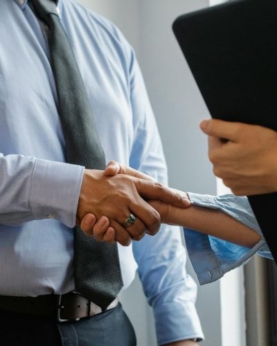 man and woman shaking hands in office