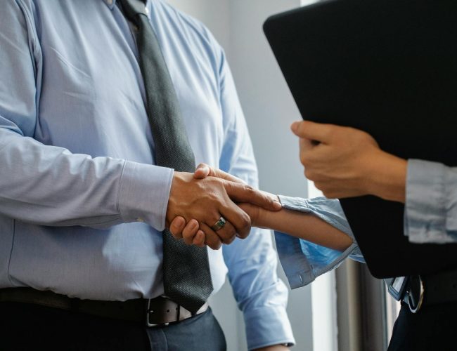 man and woman shaking hands in office