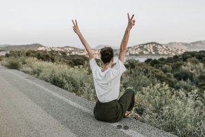 Photo by Vlada Karpovich on <a href="https://www.pexels.com/photo/woman-sitting-on-the-road-making-a-peace-sign-7902950/" rel="nofollow">Pexels.com</a>