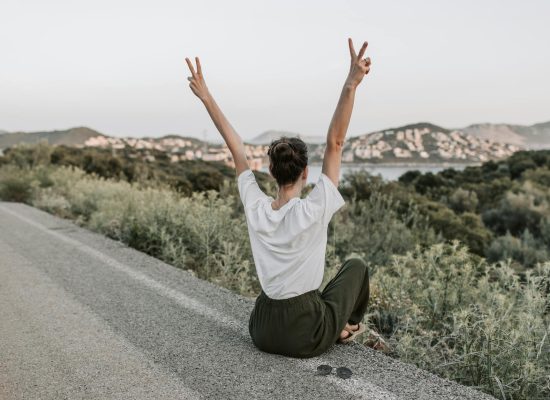 Photo by Vlada Karpovich on <a href="https://www.pexels.com/photo/woman-sitting-on-the-road-making-a-peace-sign-7902950/" rel="nofollow">Pexels.com</a>